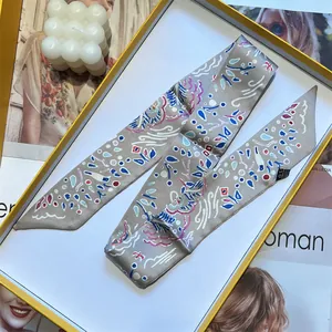 Narrow silk twilly scarf with abstract patterns in a yellow-edged gift box