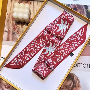 Macro shot of red printed floral twilly scarf in a gift box with fashion magazine