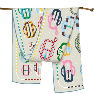 Luxurious long silk scarf with colorful belt buckle print draped on a wooden branch