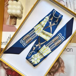 French equestrian blue twilly silk scarf with yellow horse bit pattern in a gift box