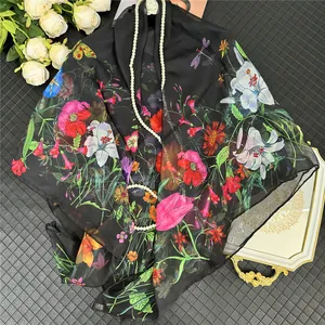 Dettaglio elegante sciarpa di seta nera con papaveri rossi, gigli e farfalle decorative