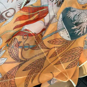Detail van lichte oranje zijden sjaal met vintage bloemen en botanische patronen