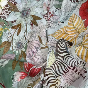 Detail van lichte sjaalstof met artistieke zebra- en tropische bloemenprints