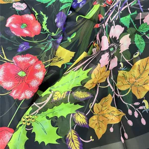 Dettaglio del tessuto georgette floreale con stampe di papaveri e texture leggera