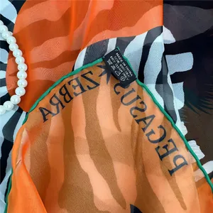 Detailed view of 100% silk scarf with zebra print and authentic material wash label