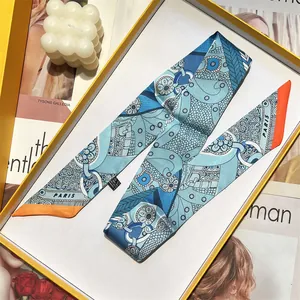 Pañuelo estrecho de satén azul con motivos de cadenas y caja de regalo amarilla