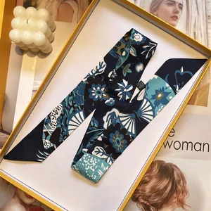 Detalle de un pañuelo Twilly de seda azul y blanco con flores en caja de regalo