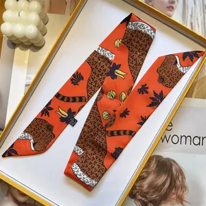 Detailed view of leopard print silk scarf in a premium gift box with fashion accessories