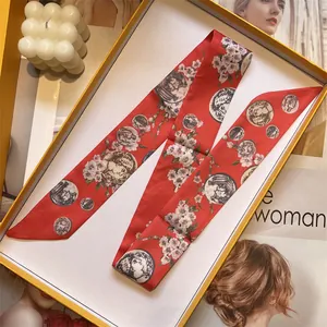 Narrow red silk twilly scarf with floral cherry blossom print in a yellow gift box