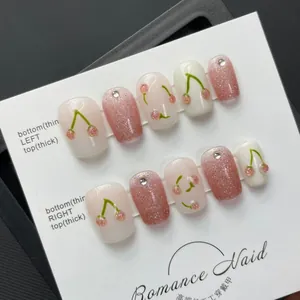 Handmade cat eye press-on nails with 3D green cherry designs and pink glitter accents