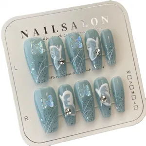 Uñas postizas artesanales con diseño de mariposa azul y purpurina plateada forma ataúd