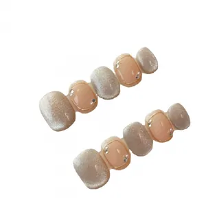 Handmade nude pink cat eye press-on nails with elegant pearls and crystal accents