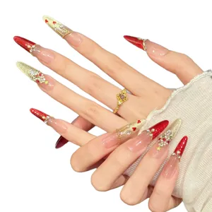 Christmas themed stiletto press-on nails with red gold glitter and zircon heart accents
