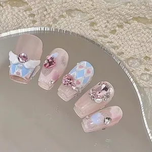 Handmade pink and blue press-on nails with 3D angel wings and crystal hearts