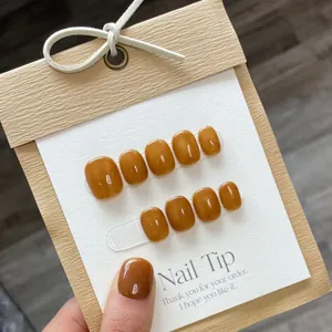 Glossy amber brown handmade press-on nails set on a gift display card with short square shape