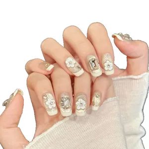 Champagne gold glitter press-on nails with 3D white flowers and sparkling rhinestones