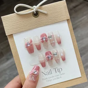 Faux ongles faits main dégradé rose avec nœuds 3D, cœurs et détails de perles fines