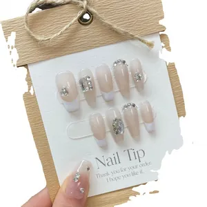 Handmade French gradient nail tips in nude white with rhinestones on a premium display card