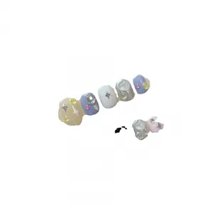 Star and heart themed press-on nails in pastel purple, white and cream tones