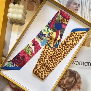 Detail van kleurrijke zijden sjaal met bloemenprint in een gele geschenkverpakking