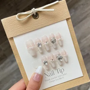 Uñas postizas artesanales nude francés con perlas y cristales en tarjeta