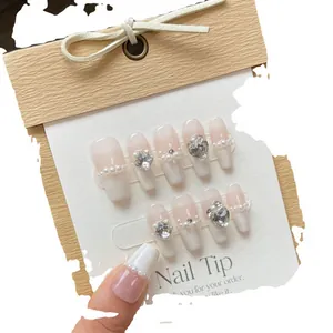 Uñas postizas nude hechas a mano con perlas, degradado blanco y diamantes de corazón