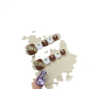 Brown and white press-on toenails with gold chain and purple 3D butterfly nail art