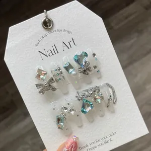 Faux ongles mariée faits main blancs avec cœurs en cristal 3D et nœuds argentés