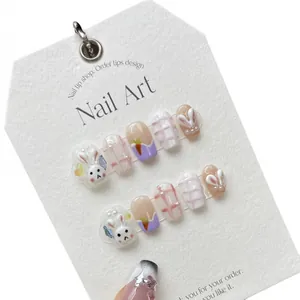 Handmade press-on nails with cute hand-painted bunny, carrot and pink grid texture