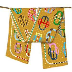Detail of mustard yellow silk scarf with white dots and colorful equestrian horse buckle print
