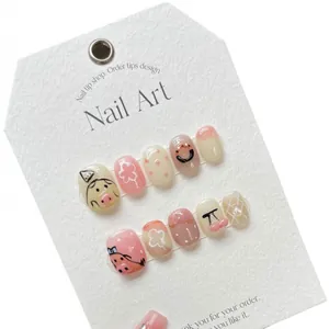 Cute handmade press-on nails with 3D pig, cherry, and donut designs on display card