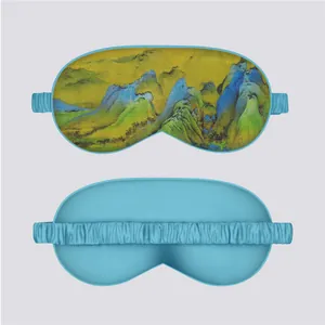 Detail showing the landscape art print on front and solid blue back of silk sleep mask