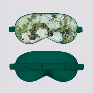 Front and back view of a luxury dark green silk sleep mask with artistic floral print