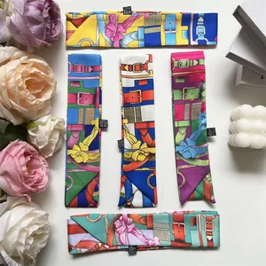 Detail von bunten Twilly-Seidenschals mit floralem Print und Vintage-Gürtelmuster-Elementen