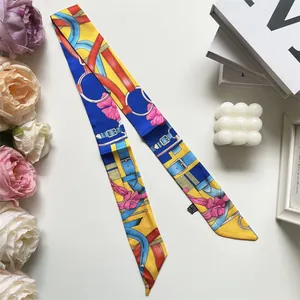 Detailaufnahme eines Seidenschals mit Blumenmuster und Gürtelschnallen-Motiv für Taschen