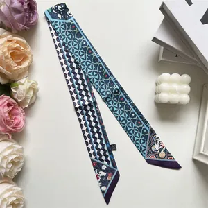 Detail of artistic long skinny scarf with blue geometric patterns in a lifestyle setting