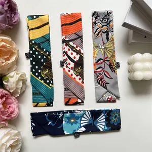 Plano de cuatro pañuelos twilly de poliéster con estampados florales y lunares sobre fondo blanco