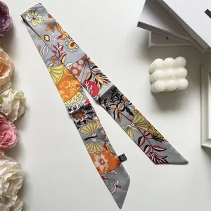 Primer plano de bufanda de poliéster gris con estampado floral y bordes de corte diagonal