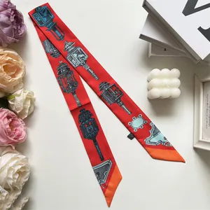 Detailopname van rode smalle twilly sjaal met vintage lantaarnprint en scherpe hoek