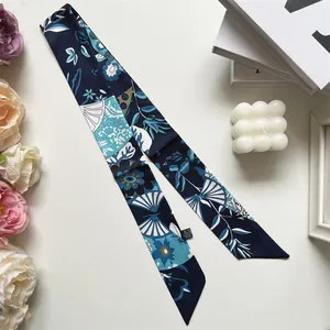 Detalle de un pañuelo largo de seda con estampado floral azul y blanco estilo bohemio