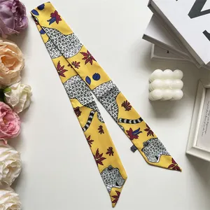 Detail view of yellow leopard print twilly silk scarf with floral patterns on white background