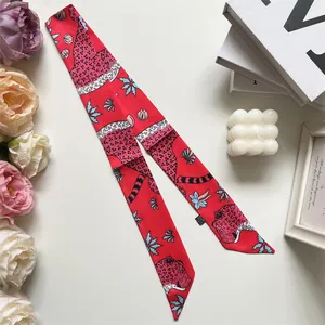 Detail of red leopard print silk twilly scarf with floral patterns and fabric care label