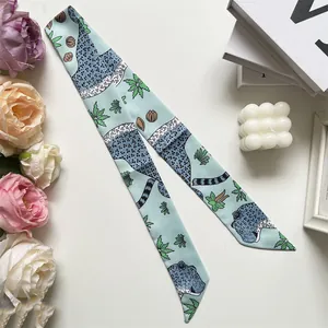 Detail of mint green leopard print silk twilly scarf with floral decorative elements