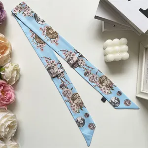 Detail of 100% silk twilly with pink cherry blossoms and vintage coin patterns on light blue