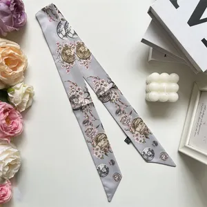Detailed macro view of narrow silk scarf with floral print and vintage coin patterns