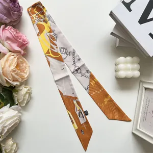 Detail of elegant orange and yellow silk twilly scarf with vintage equestrian pattern