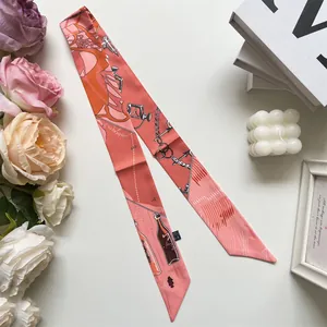 Detail of pink and coral silk twilly scarf with horse harness patterns on aesthetic backdrop