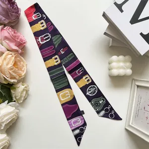 Detail of a luxury purple silk twilly scarf with colorful equestrian belt pattern prints