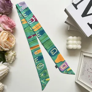 Detail of green floral ribbon scarf wrapped on books with elegant lifestyle accessories
