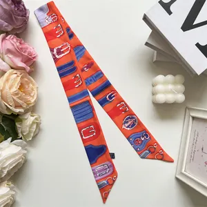 Detail of vintage equestrian horse bit printed orange silk twilly scarf for handbag decor